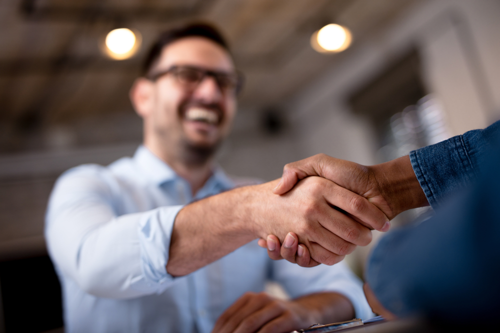 Businessmen shaking hands after finalizing a partnership with a trusted audio visual equipment supplier in New Orleans.