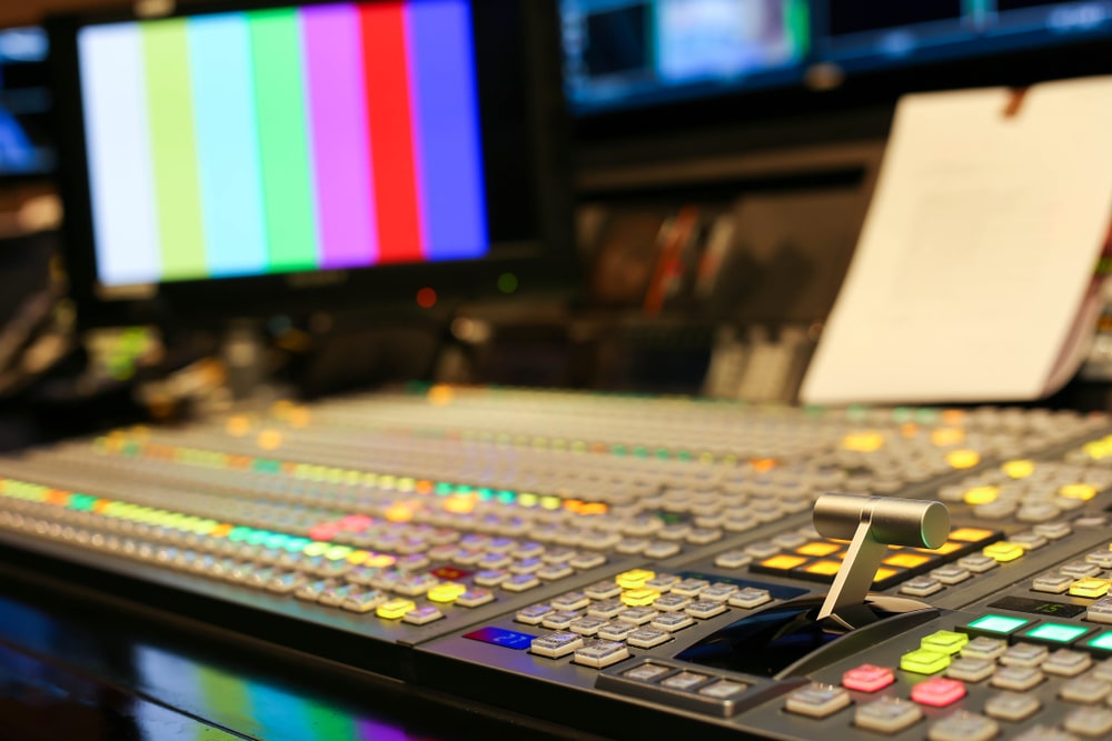 Switching buttons in a TV studio station, demonstrating audio and video production switches for broadcast, relevant to audio visual equipment synchronization.
