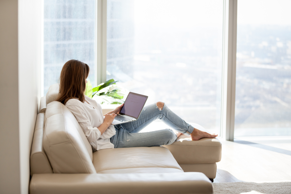 Person comfortably using laptop at home for work or entertainment. audio visual equipment